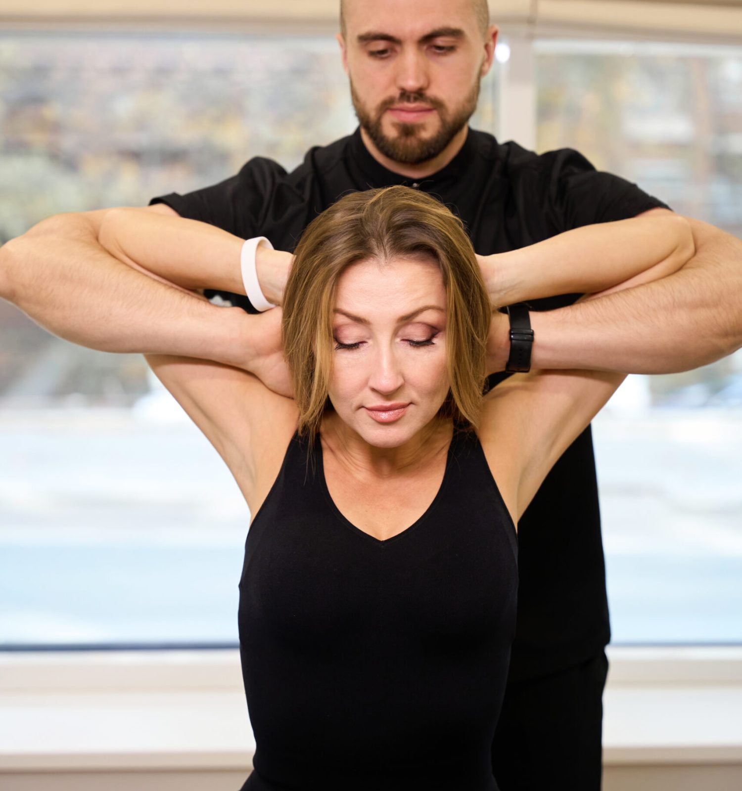 Chiropractor is conducting an appointment at a wellness center, he is working with the patients spine