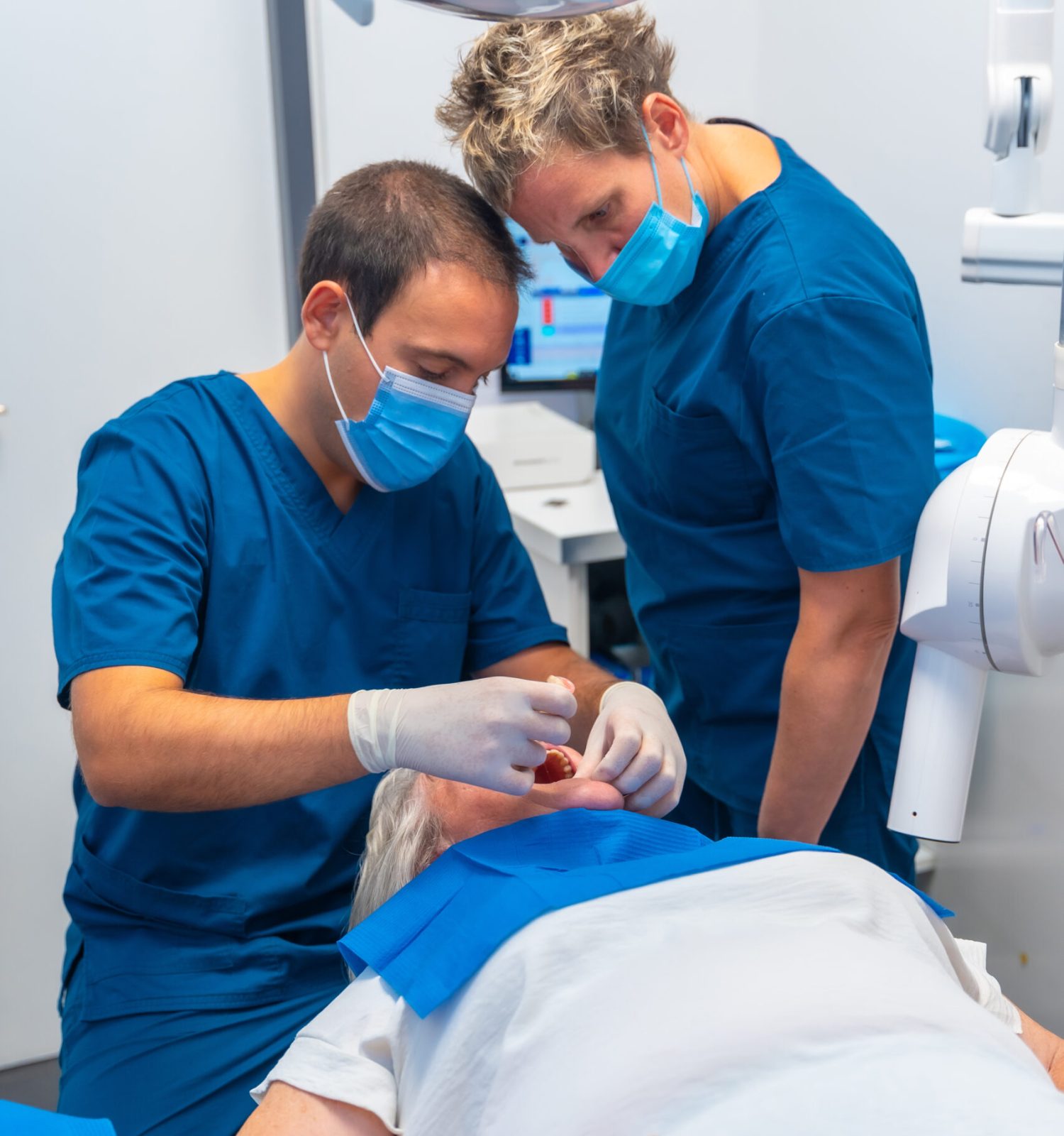Dental clinic, dentist doctor and assistant examining the teeth of an elderly woman