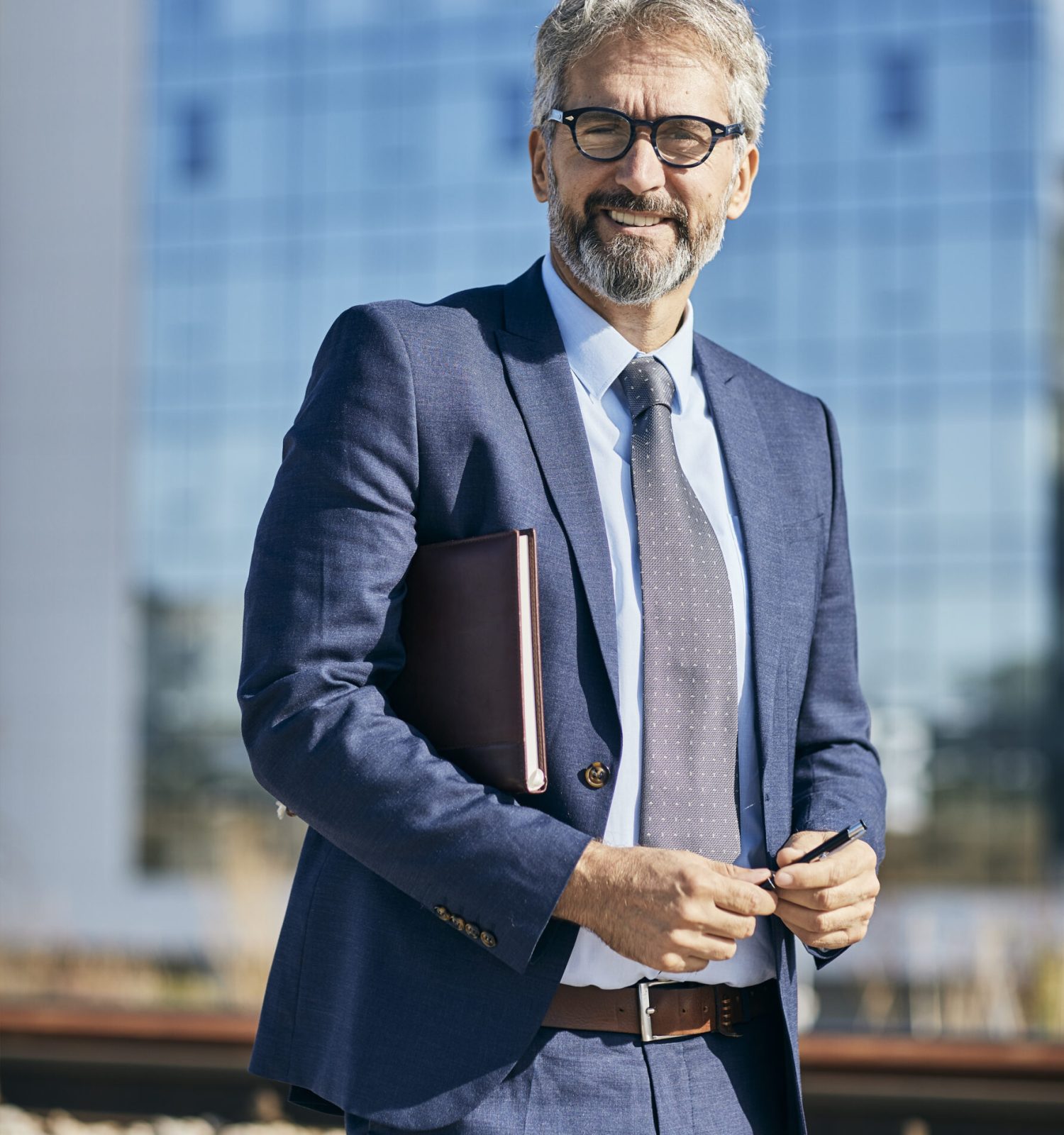 portrait of a senior businessman in front of corporate buildings